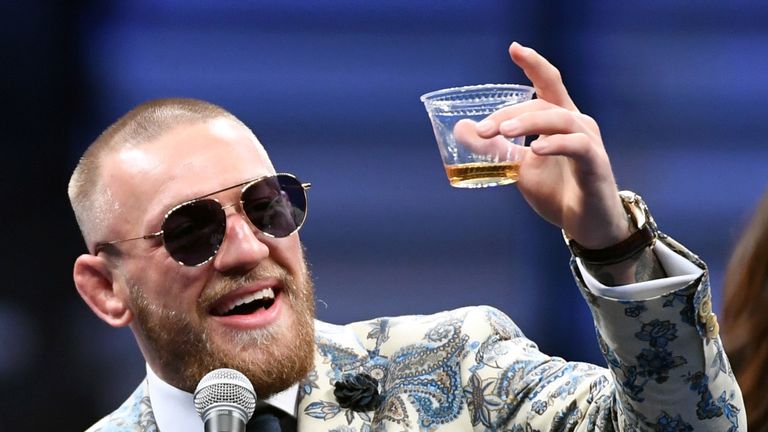 LAS VEGAS, NV - AUGUST 26:  Conor McGregor holds up a cup of his Notorious-branded Irish whiskey as he speaks during a news conference following his 10th-r