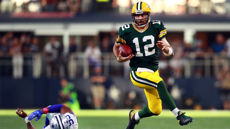 ARLINGTON, TX - OCTOBER 08:  Aaron Rodgers #12 of the Green Bay Packers scrambles with the ball against David Irving #95 of the Dallas Cowboys in the fourt