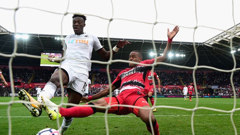 SWANSEA, WALES - OCTOBER 14: Swansea striker Tammy Abraham scores his second goal despite the challenge of Zanka  during the Premier League match between S