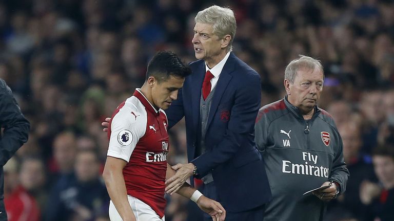 Arsenal's Chilean striker Alexis Sanchez passes Arsene Wenger as he substituted off of the pitch during the game v WBA on September 25, 2017