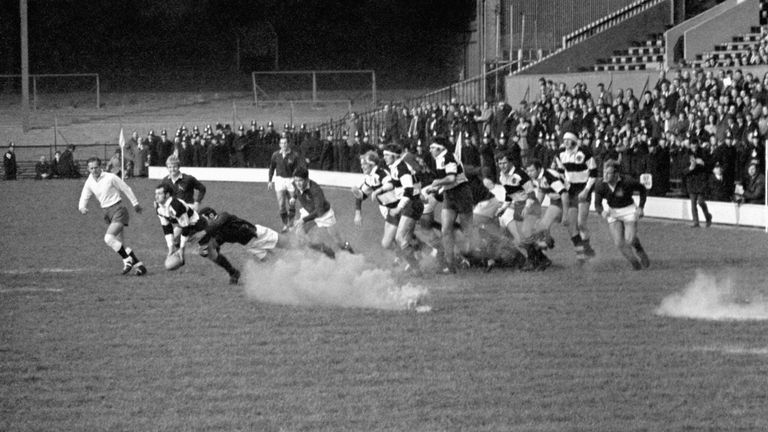 An orange smoke bomb is thrown on to the pitch by anti-apartheid protestors, during the final match of South Africa's current tour, against the Barbarians 
