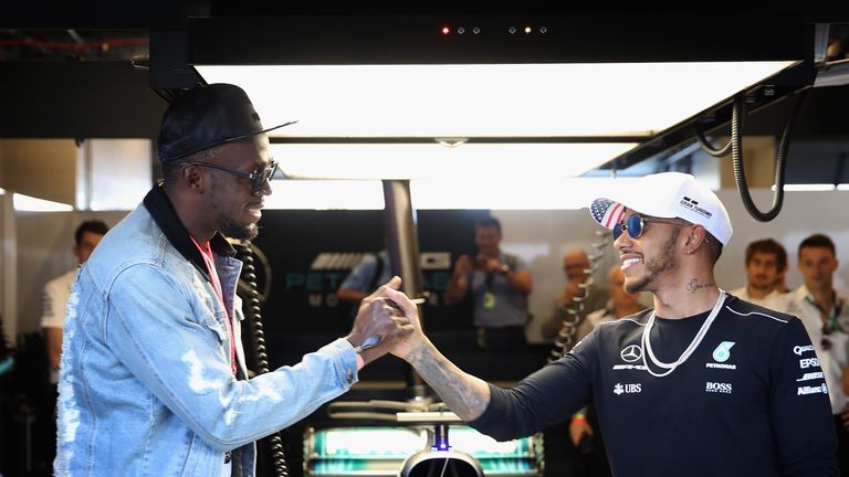 AUSTIN, TX - OCTOBER 22:  Sprinting legend Usain Bolt shakes hands with Lewis Hamilton of Great Britain and Mercedes GP in the Mercedes F1 garage before th