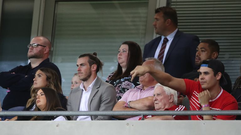 Gareth Bale watches the Ireland game with Sonny Coleman, son of Wales manager Chris, (right in hat) and wife Emma Rhys-Jones (left) 