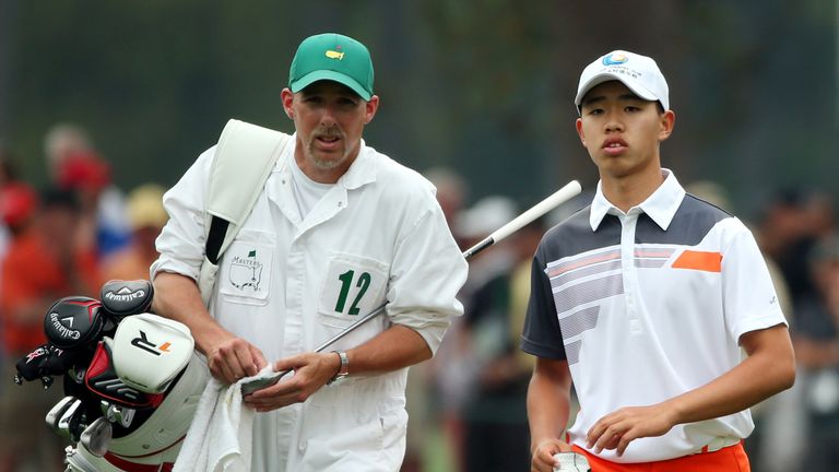 AUGUSTA, GA - APRIL 14:  Tianlang Guan of China stands with his caddie on the 8th hole during the final round of the 2013 Masters Tournament at Augusta Nat
