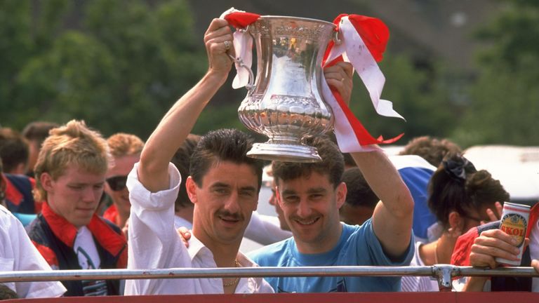 May 1989:  Ian Rush (left) and John Aldridge (right) both of Liverpool hold the trophy aloft as they stand on the top deck of a bus during their homecoming