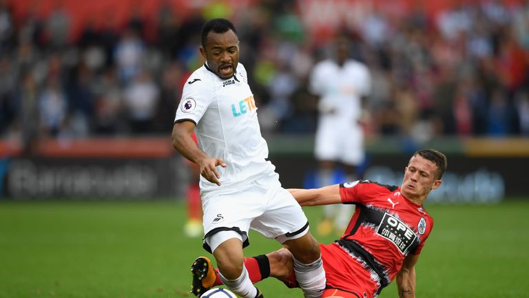 SWANSEA, WALES - OCTOBER 14:  Town player Jonathan Hogg fouls Jordan Ayew of Swansea and receives a yellow card for it during the Premier League match betw