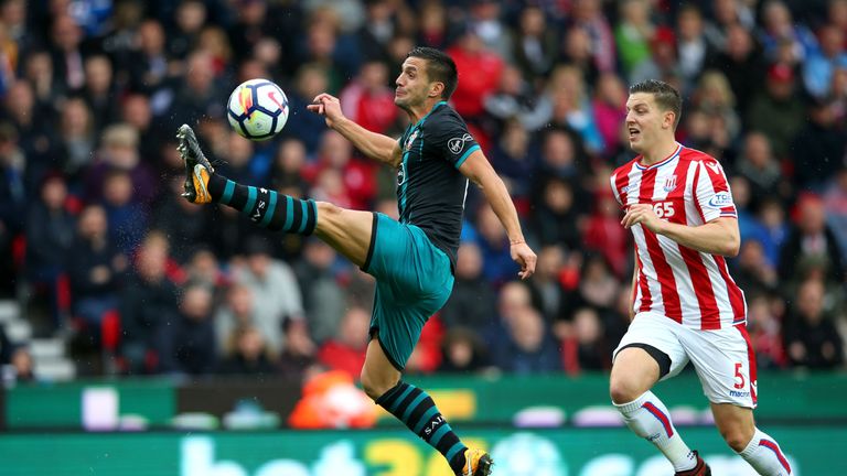 STOKE ON TRENT, ENGLAND - SEPTEMBER 30: Dusan Tadic of Southampton controls the ball while under pressure from Kevin Wimmer of Stoke City during the Premie