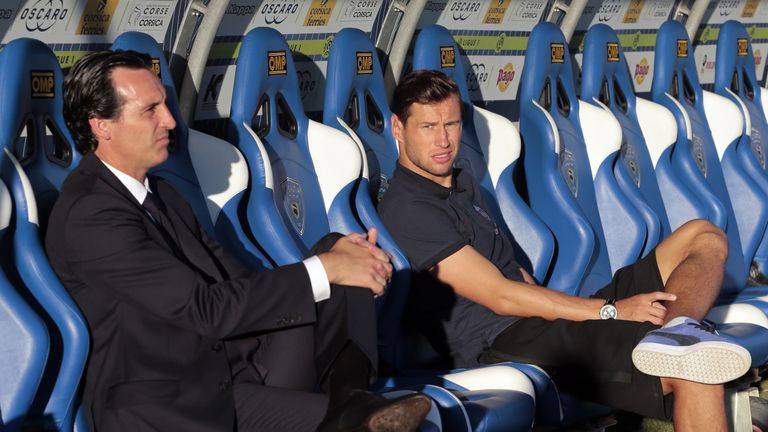 Paris Saint-Germain's Spanish head coach Unai Emery (L) and Paris Saint-Germain's Polish defender Grzegorz Krychowiak sit on the stands prior to the French