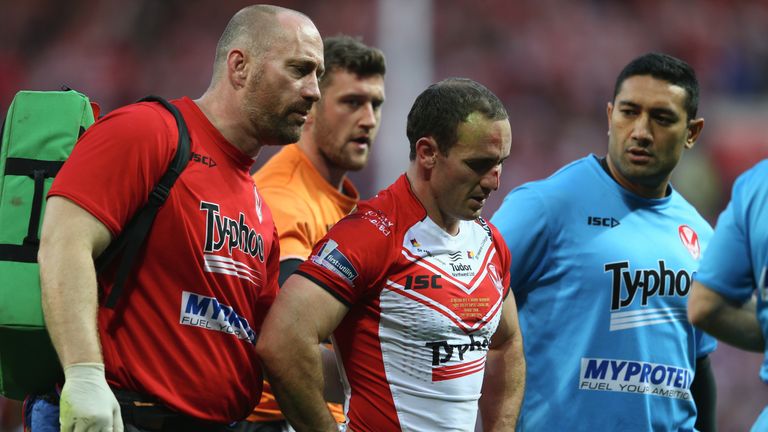 MANCHESTER, ENGLAND - OCTOBER 11:  Lance Hohaia (C) of St Helens is helped off the field by medics after being punched by Ben Flower of Wigan who was shown