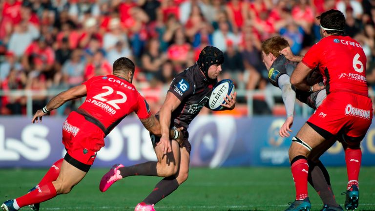 Llanelli Scarlets fullback Leigh Halfpenny (C) avoids the tackle from RC Toulon's French scrum-half  Sebastien Tillous-Borde (L) during the European Champi