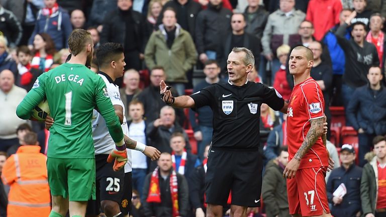 Referee Martin Atkinson separates Manchester United's Spanish goalkeeper David de Gea (L) and Liverpool's Slovakian defender Martin Skrtel (R) during the E
