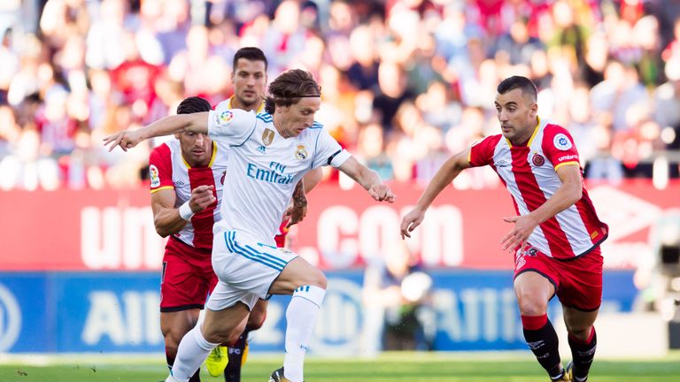 Luka Modric of Real Madrid CF conducts the ball between Francisco Aday (L) and Borja Garcia (R) of Girona FC during the La Liga