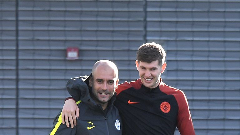 Pep Guardiola (L) with Manchester City defender John Stones (R)