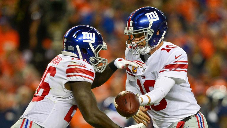 DENVER, CO - OCTOBER 15:  Quarterback Eli Manning #10 of the New York Giants hands off to Orleans Darkwa #26 during a game at Sports Authority Field at Mil