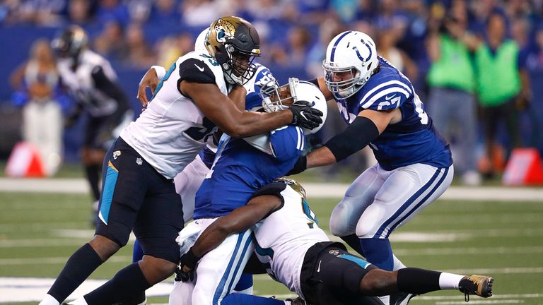 INDIANAPOLIS, IN - OCTOBER 22:  Jacoby Brissett #7 of the Indianapolis Colts is hit by Calais Campbell #93 of the Jacksonville Jaguars after throwing a pas