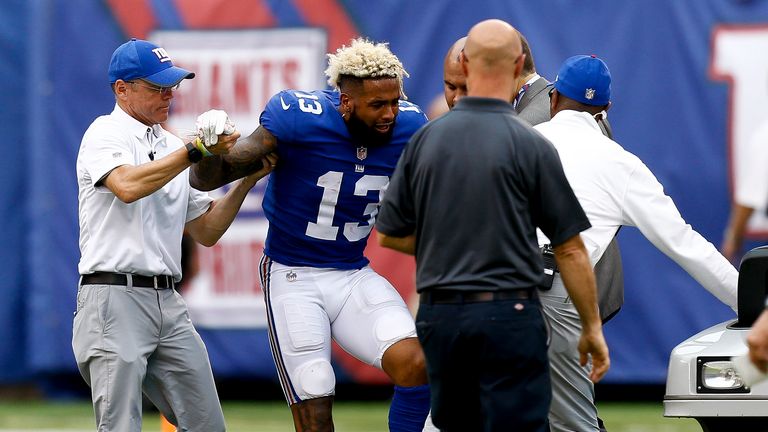 Odell Beckham #13 of the New York Giants is helped by team staff after being injured