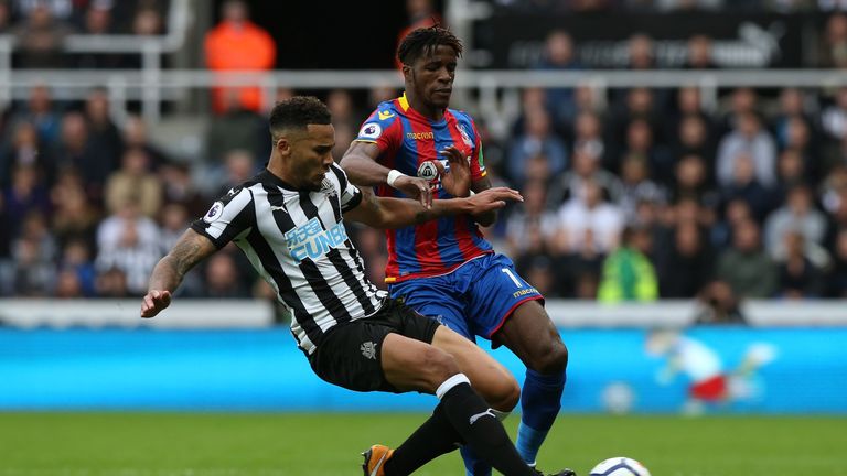 NEWCASTLE UPON TYNE, ENGLAND - OCTOBER 21:  Wilfried Zaha of Crystal Palace is tackled by Jamaal Lascelles of Newcastle United during the Premier League ma
