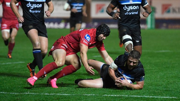 Rhys Priestland's slide towards the line is stopped by Scarlets' Leigh Halfpenny