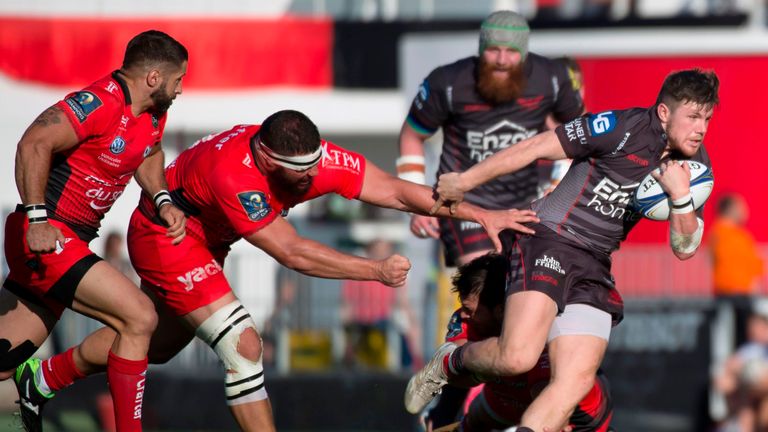 Llanelli's Welsh fullback Steffan Evans (R) avoids a tackle from RC Toulon's defenders during the European Champions Cup rugby union match between RC Toulo