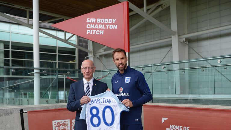 Sir Bobby Charlton is presented with a signed shirt by Gareth Southgate after a pitch at St George's Park is named after him.