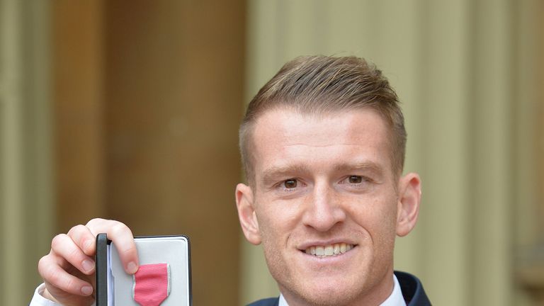 Footballer Steven Davis holds the MBE presented to him by the Duke of Cambridge at the Investiture ceremony