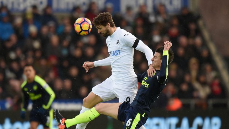 SWANSEA, WALES - JANUARY 14:  Fernando Llorente of Swansea City is tackled by Laurent Koscielny of Arsenal during the Premier League match between Swansea 