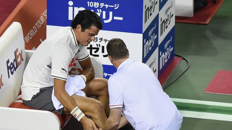 Milos Raonic of Canada receives medical attention during his match against Yuichi Sugita of Japan Open