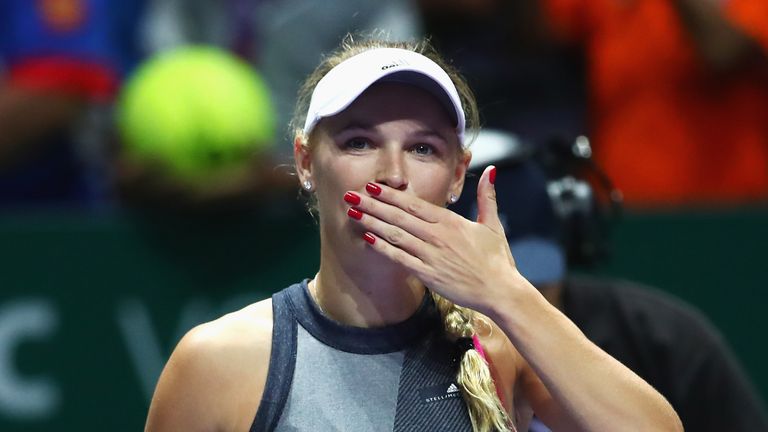 Caroline Wozniacki of Denmark celebrates victory in her singles match against Simona Halep of Romania