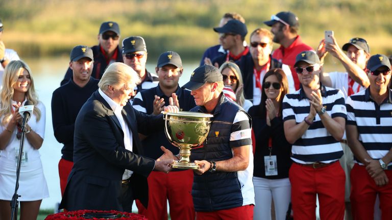 JERSEY CITY, NJ - OCTOBER 01:  U.S. President Donald Trump presents Captain Steve Stricker and the U.S. Team with the trophy after they defeated the Intern