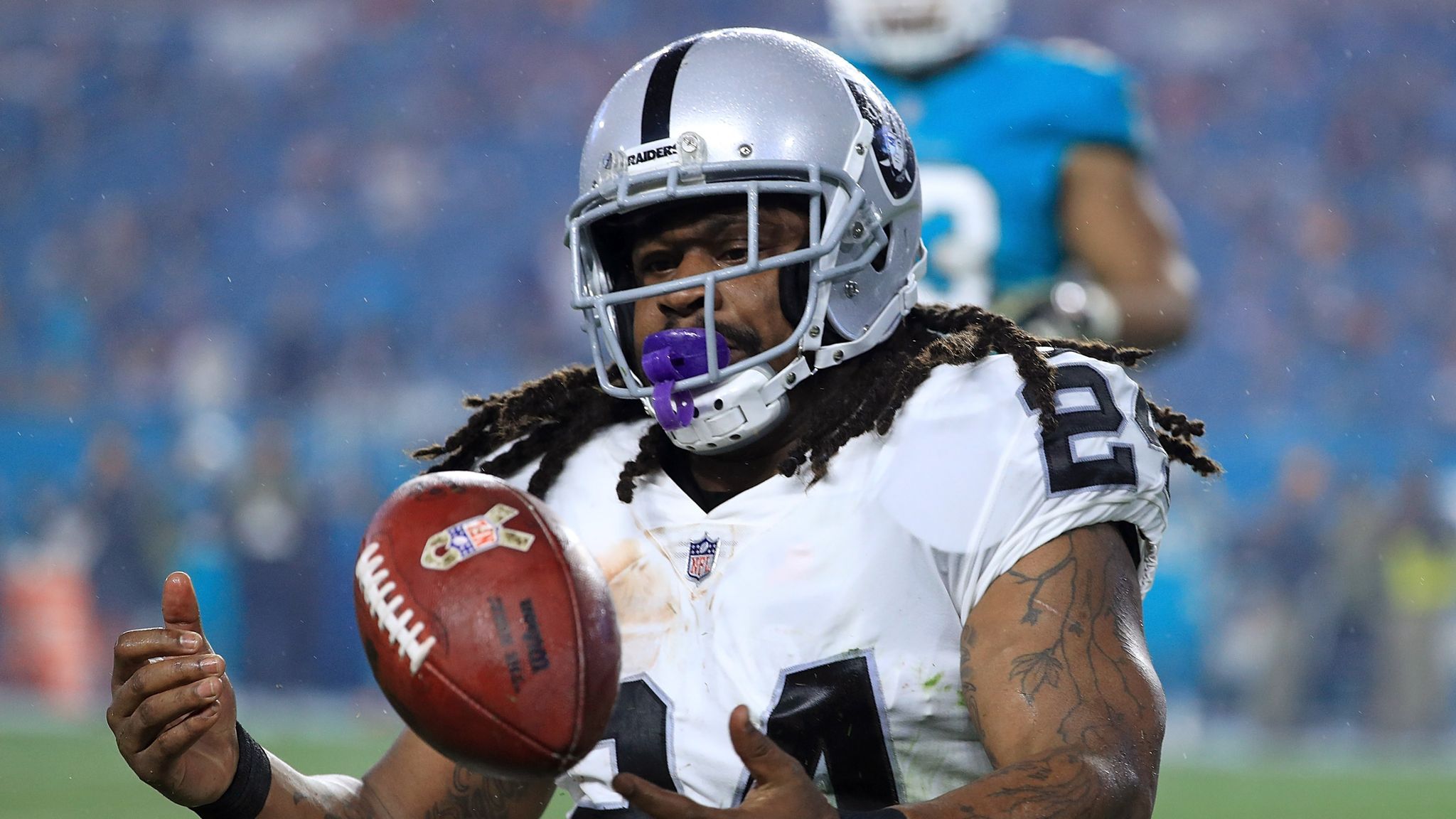 Raiders RB Marshawn Lynch sits during national anthem