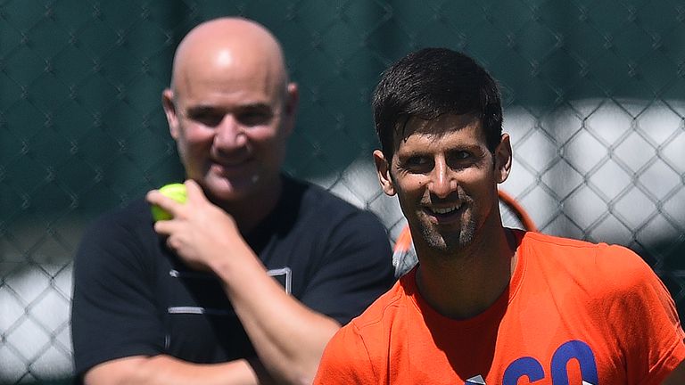 US coach Andre Agassi (L) watches Serbia's Novak Djokovic as he attends a practice session at The All England Tennis Club in Wimbledon, southwest London, o