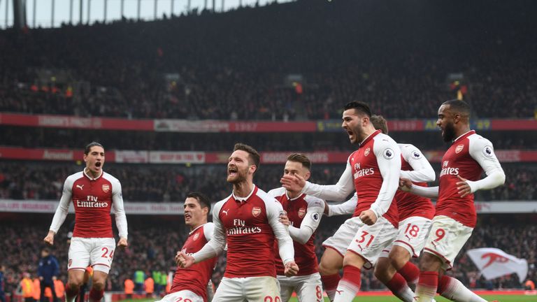 Arsenal players celebrate with Skhodran Mustafi after his opening goal in the win over Tottenham
