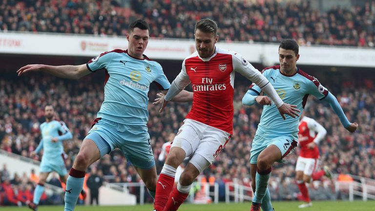 Aaron Ramsey of Arsenal holds off Michael Keane (left) and Matthew Lowton (right) of Burnley at the Emirates