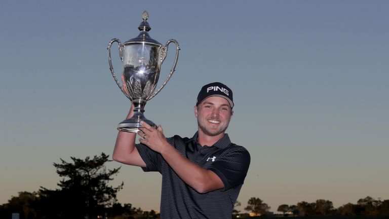 Austin Cook celebrates with the trophy after winning the RSM Classic