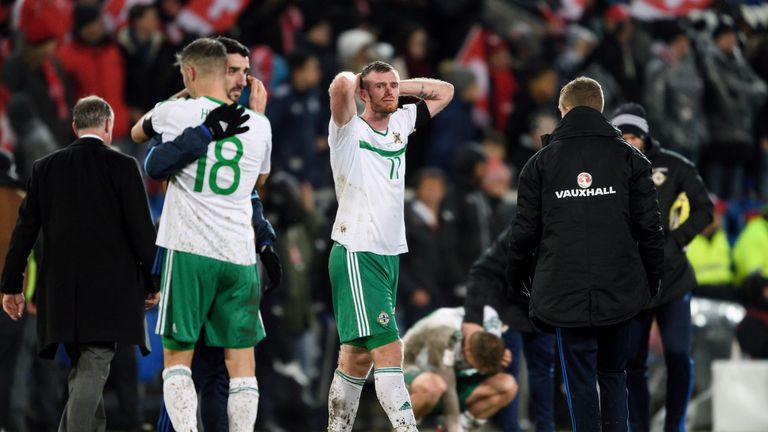 Northern Ireland's defender Aaron Hughes (L) and teammates midfielder Chris Brunt (C) react after their team failed to qualifiy at the end of the FIFA 2018