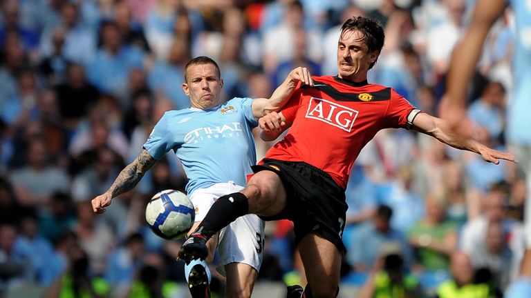 Craig Bellamy competes for the ball with Gary Neville
