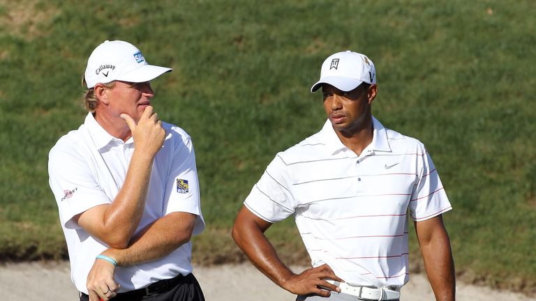 Ernie Els of South Africa (L) and Tiger Woods wait to play a shot 