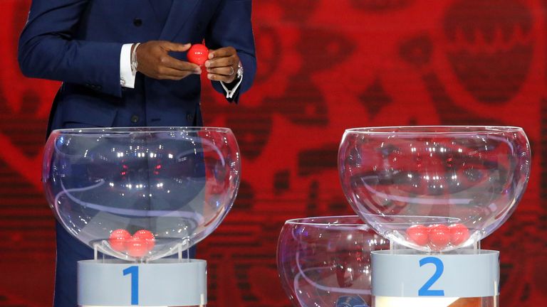 A draw assistant waits to reveal the name of a country during the preliminary draw for the 2018 World Cup qualifiers at the Konstantin Palace in Saint Pete
