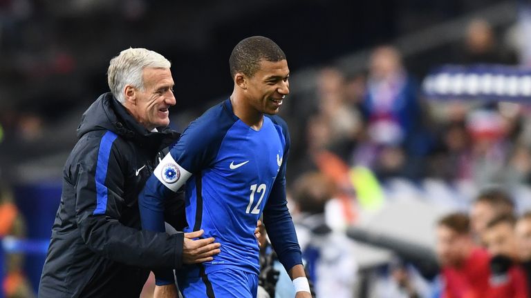 France's coach Didier Deschamps (L) congratulates France's forward Kylian Mbappe (R) as he leaves the pitch during the friendly football match between Fran