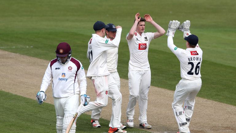 NORTHAMPTON, ENGLAND - APRIL 11:  George Garton of Sussex is congratulated by team mates after taking the wicket of Adam Rossington during the Specsavers C