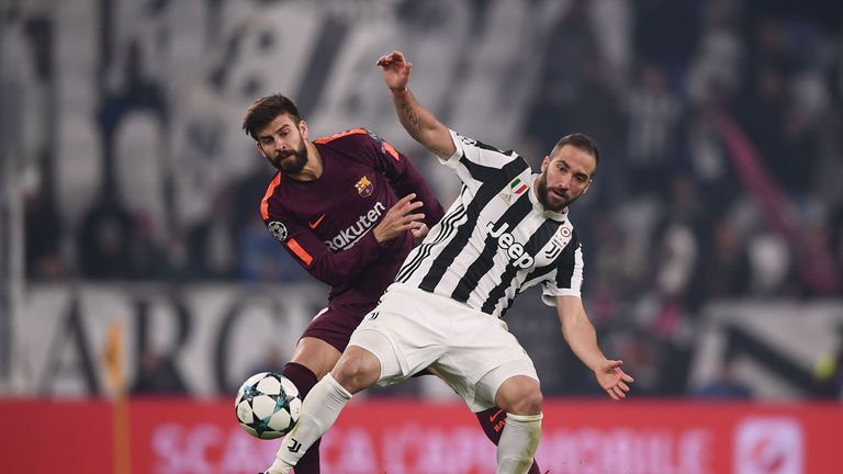 Barcelona defender Gerard Pique battles for the ball with Juventus Gonzalo Higuain 