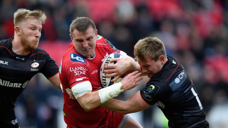 LLANELLI, WALES - JANUARY 15:  Scarlets centre Hadleigh Parkes is tackled by Nick Tompkins (r) of Saracens during the European Rugby Champions Cup match be