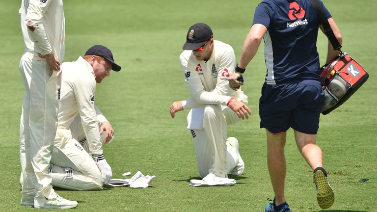 England's captain Joe Root (R) checks on Jonny Bairstow (L) after he injured his hand against Cricket Australia XI on the first day