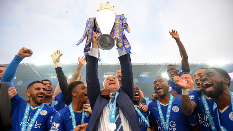 Claudio Ranieri Manager of Leicester City lifts the Premier League Trophy as players celebrate