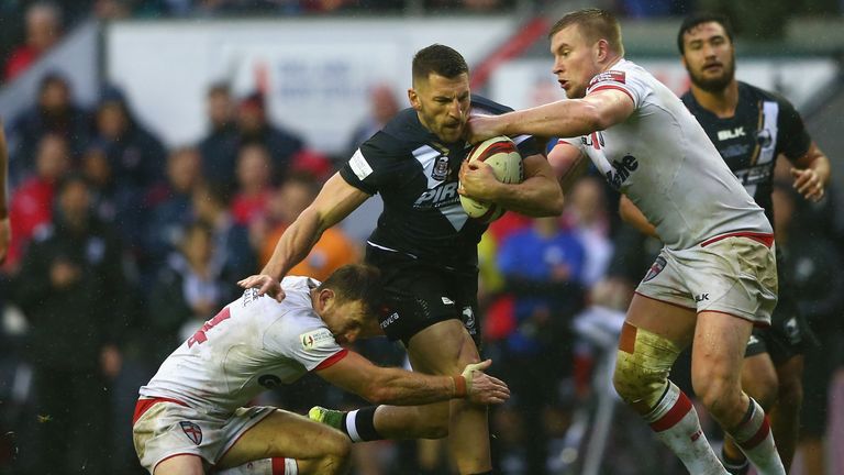 Lewis Brown of New Zealand is tackled by Tom Burgess of England