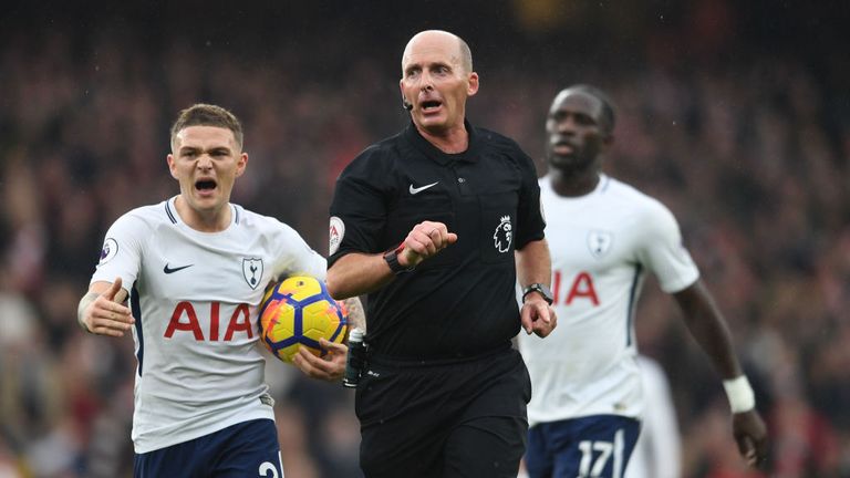 Tottenham players contest a decision made by referee Mike Dean