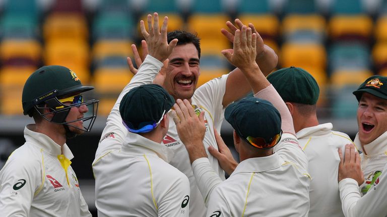 Australia's paceman Mitchell Starc (C-facing) celebrates with teammates after taking the wicket of England's batsman Jake Ball on the second day of the fir