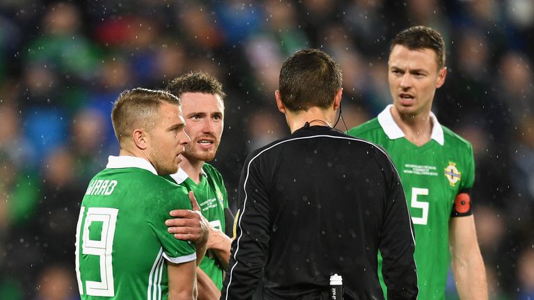 Northern Ireland players protest after the harsh penalty award