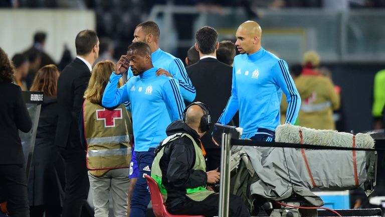 Marseille's French defender Patrice Evra (C) leaves the pitch after an incident with Marseille supporters before the start of the UEFA Europa League group 
