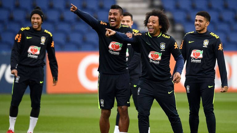 Brazil's midfielder Paulinho (L) jokes with defender Marcelo during a training session at the Parc des Princes stadium in Paris on November 8, 2017 as part